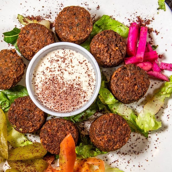 Mezza Mediterranean Grille's falafel platter with hummus, pickled turnips, and fresh vegetables.